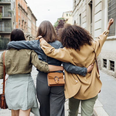 Frauen gehen Arm in Arm durch die Straße