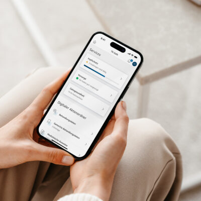 Ein Smartphone wird von zwei Händen gehalten. Auf dem Bildschirm ist die TK-App mit geöffneter ePA zu sehen