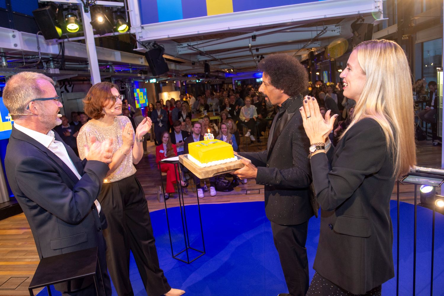 TK-Chef Dr. Jens Baas und Kirsten Ludowig (links), stellvertretende Chefredakteurin des Handelsblattes, die für Charlotte Morré einsprang, nehmen die Geburtstagstorte zum 10. Geburtstag des Health-i entgegen. 