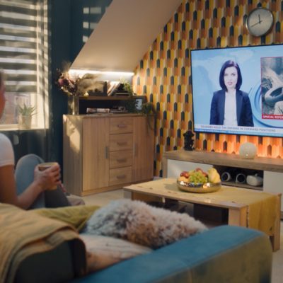 Frau schaut Nachrichten vom Sofa aus