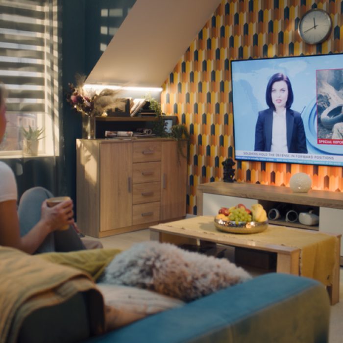 Frau schaut Nachrichten vom Sofa aus