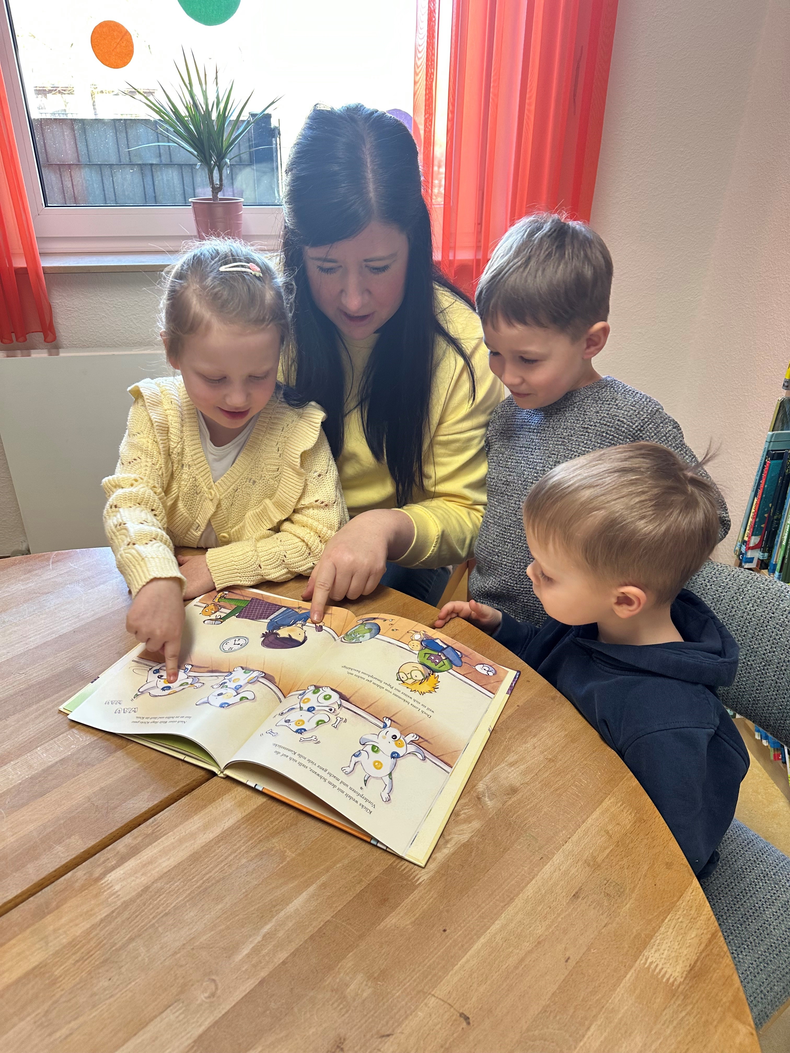 Die Kinder lesen das Kinderbuch „Lotta und Klicks“.